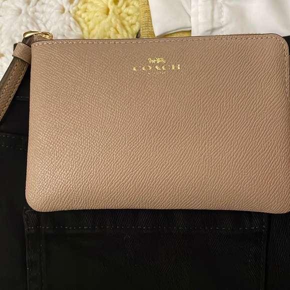 Coach Handbags - Coach wristlet in tan. Gold lettering that says COACH.